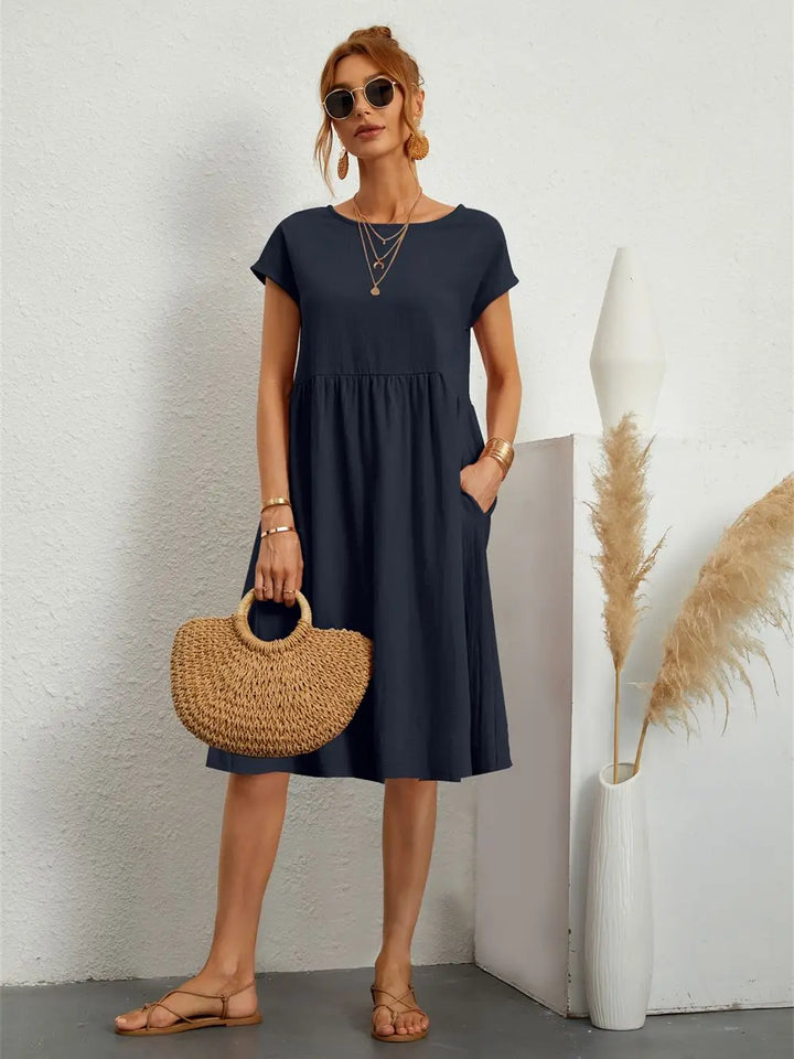Tiered women's casual midi dress with short sleeves and pockets. Comfortable, loose fit for everyday style.