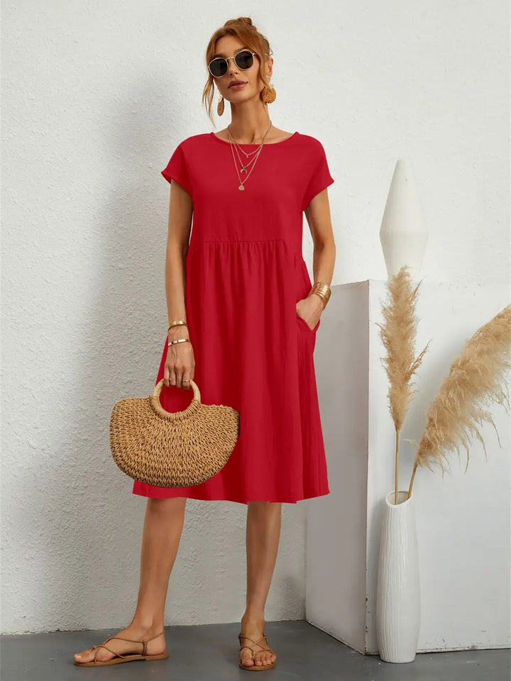Chic women's short sleeve midi dress. Loose-fit with pockets, ideal for versatile summer outfits.