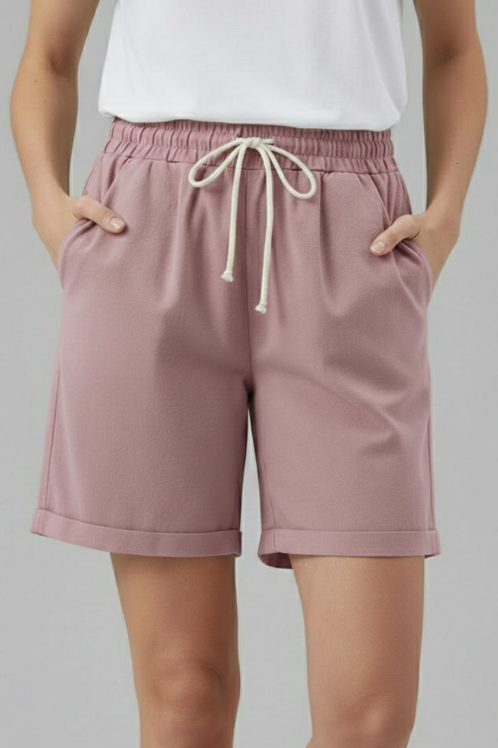 Back view of women's relaxed fit casual shorts showing pockets, elastic waist, & cuffed hem detail.