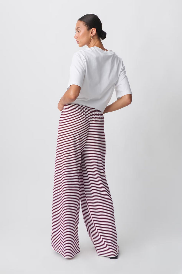 Fashionable women's pants, striped pattern and relaxed fit for chic casual spring outfits.