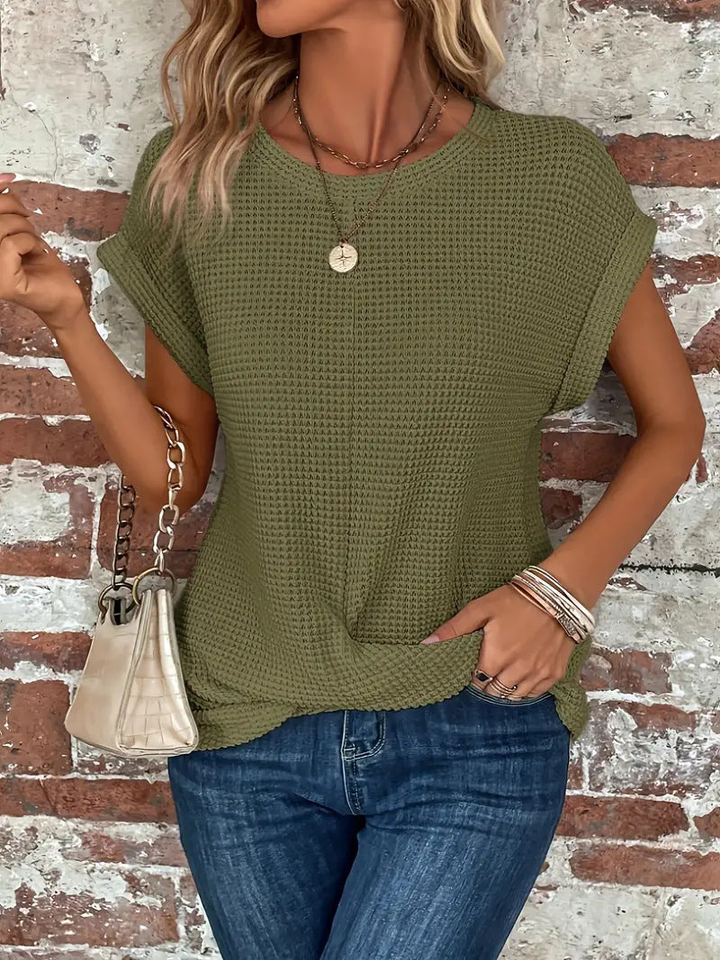 Woman modeling a casual waffle knit short sleeve top, showing its comfortable and versatile design.
