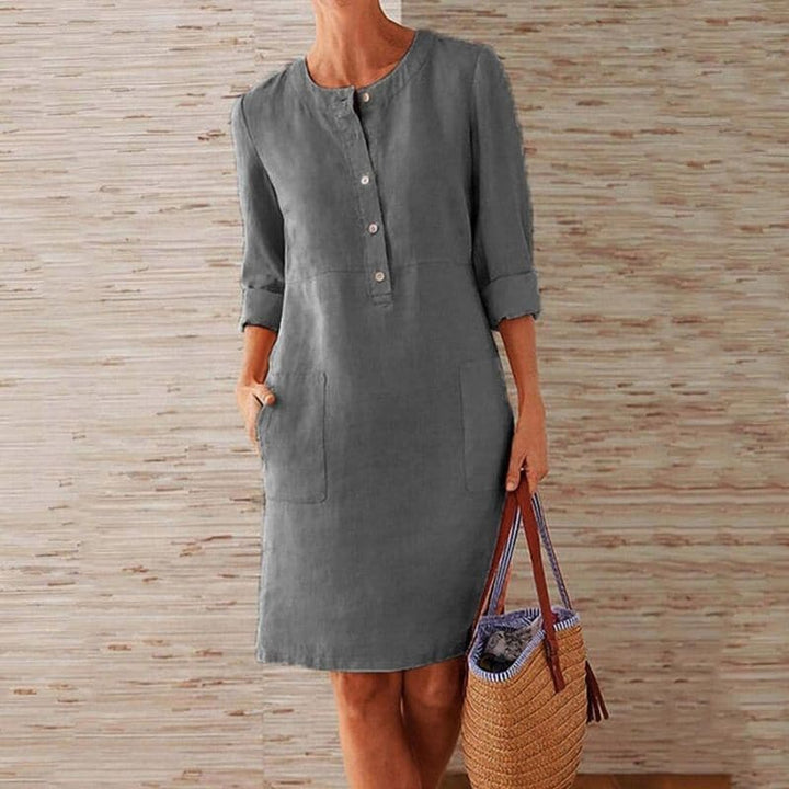 Casual knee-length women's shift dress with button-front closure, 3/4 sleeves, and handy pockets for summer.