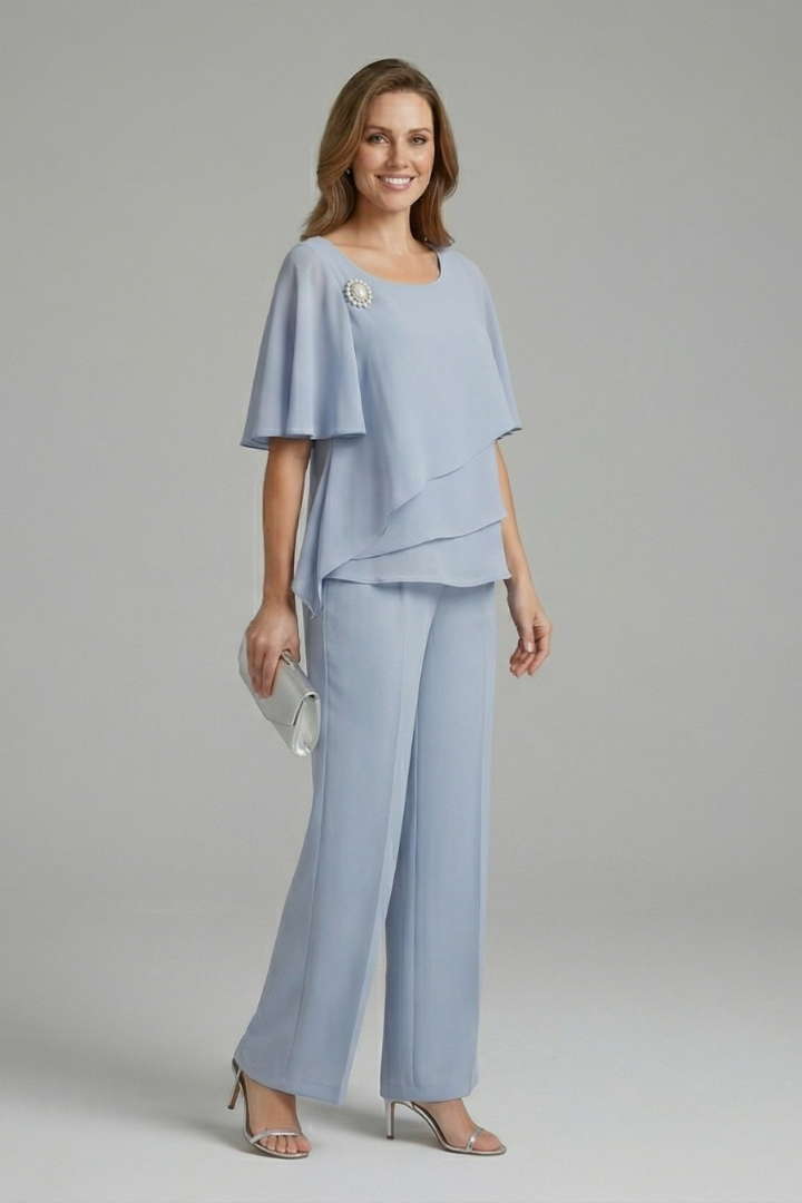 Model wears a versatile navy blue two-piece women's set with a layered top and straight leg trousers, elegant summer.