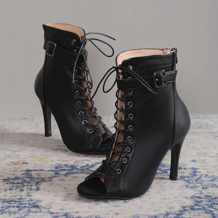 Black stiletto heels with an ankle strap and seductive lace-up front, perfect for women's nights out.