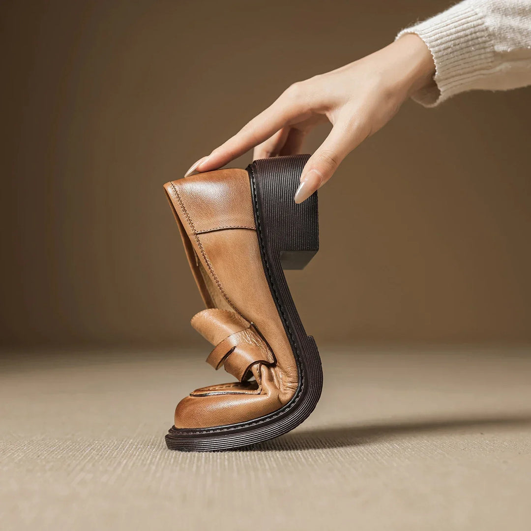 Pair of classic brown leather T-strap women's flats, offering versatile and comfortable footwear style