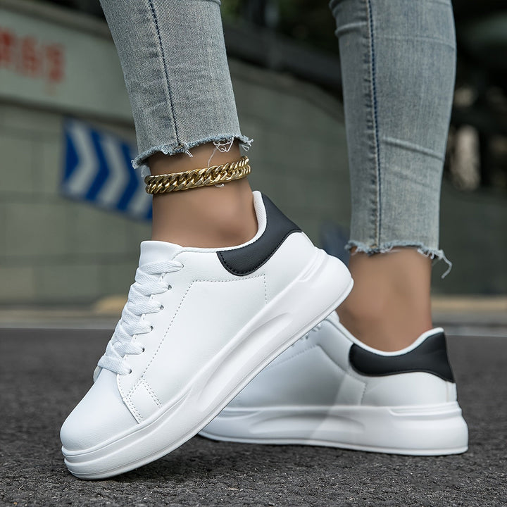Stylish women's white casual sneakers with a clean, modern look, perfect for versatile everyday outfits.
