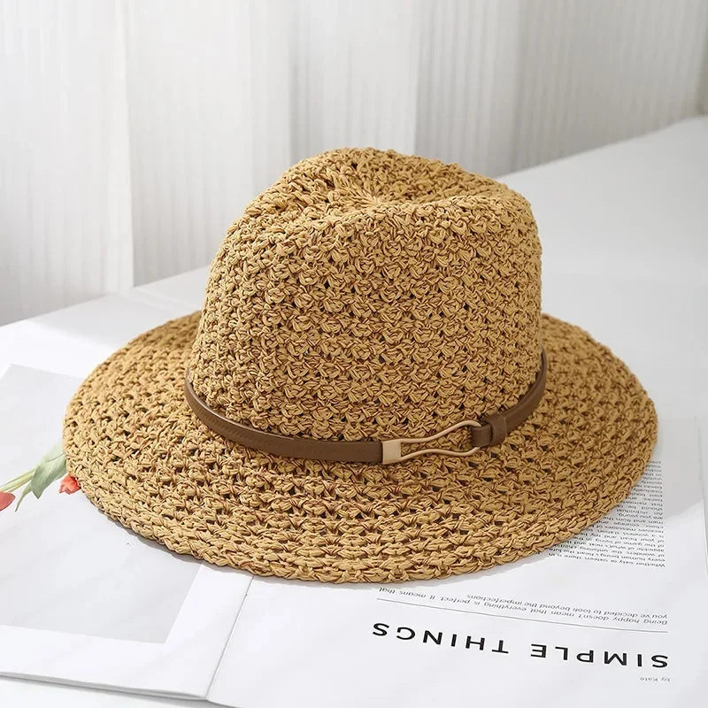 A women's woven fedora sun hat featuring a chic faux leather trim on a display head.