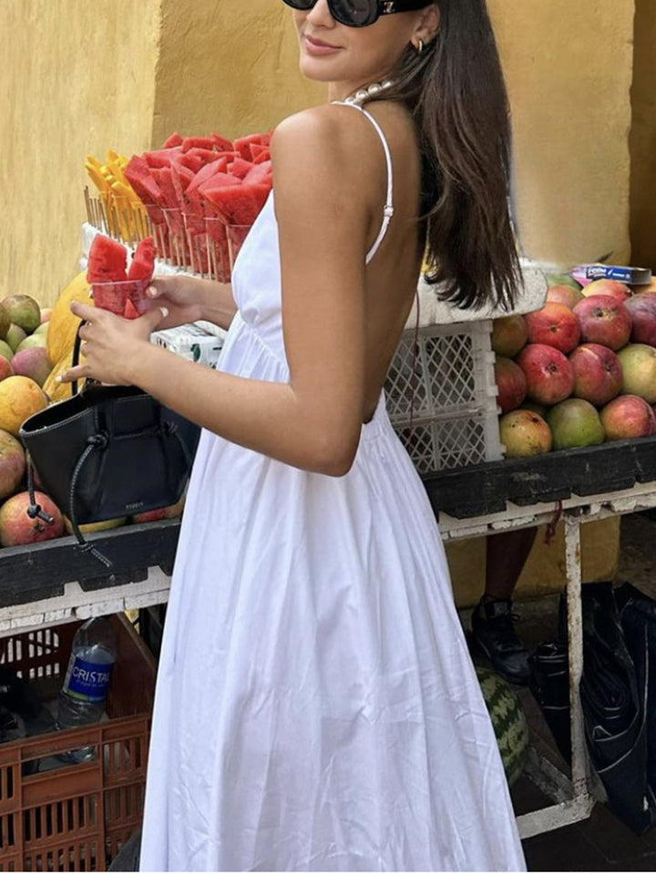 V-neck women's flowy maxi dress with open back. Coastal style summer vacation & beachwear.