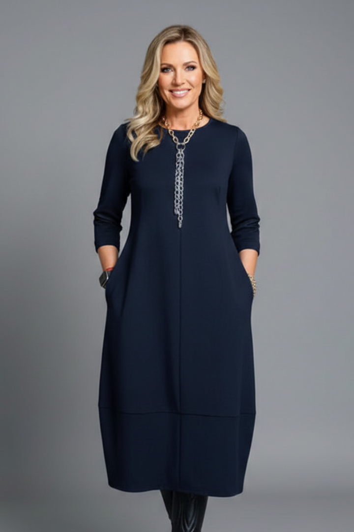 Modest women's A-line midi dress showcasing 3/4 sleeves, round neck, & convenient side pockets.