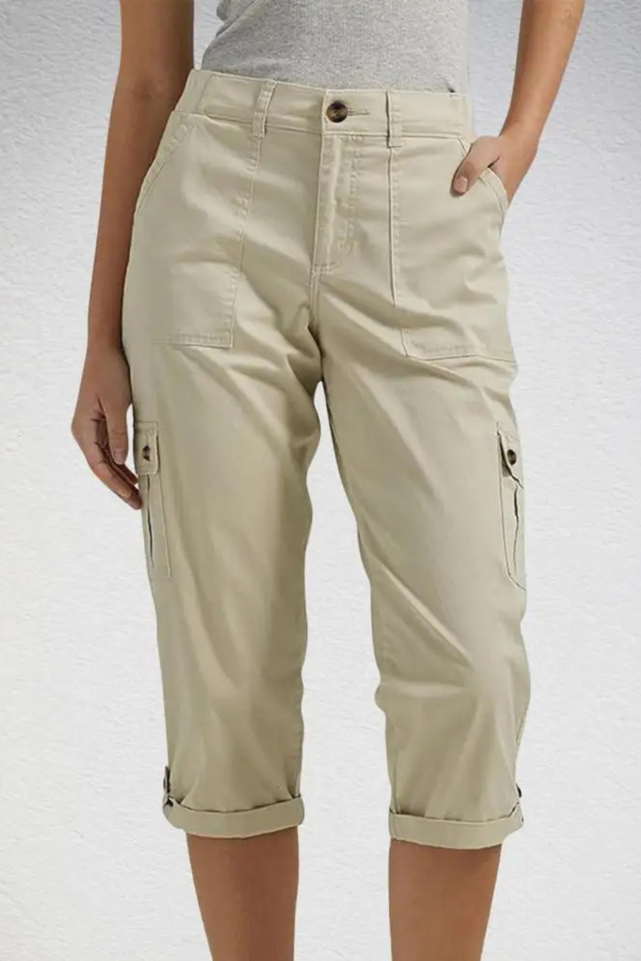 Woman sitting comfortably in relaxed fit cropped cargo pants, ideal for everyday leisure & travel.