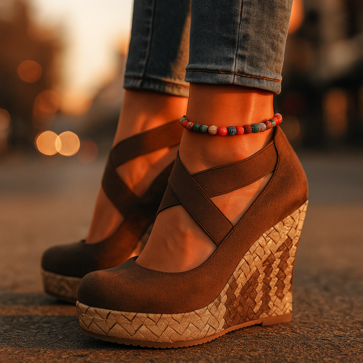 Close-up of women's comfortable brown cross strap wedge sandals; fashion orthopedic summer footwear with support.