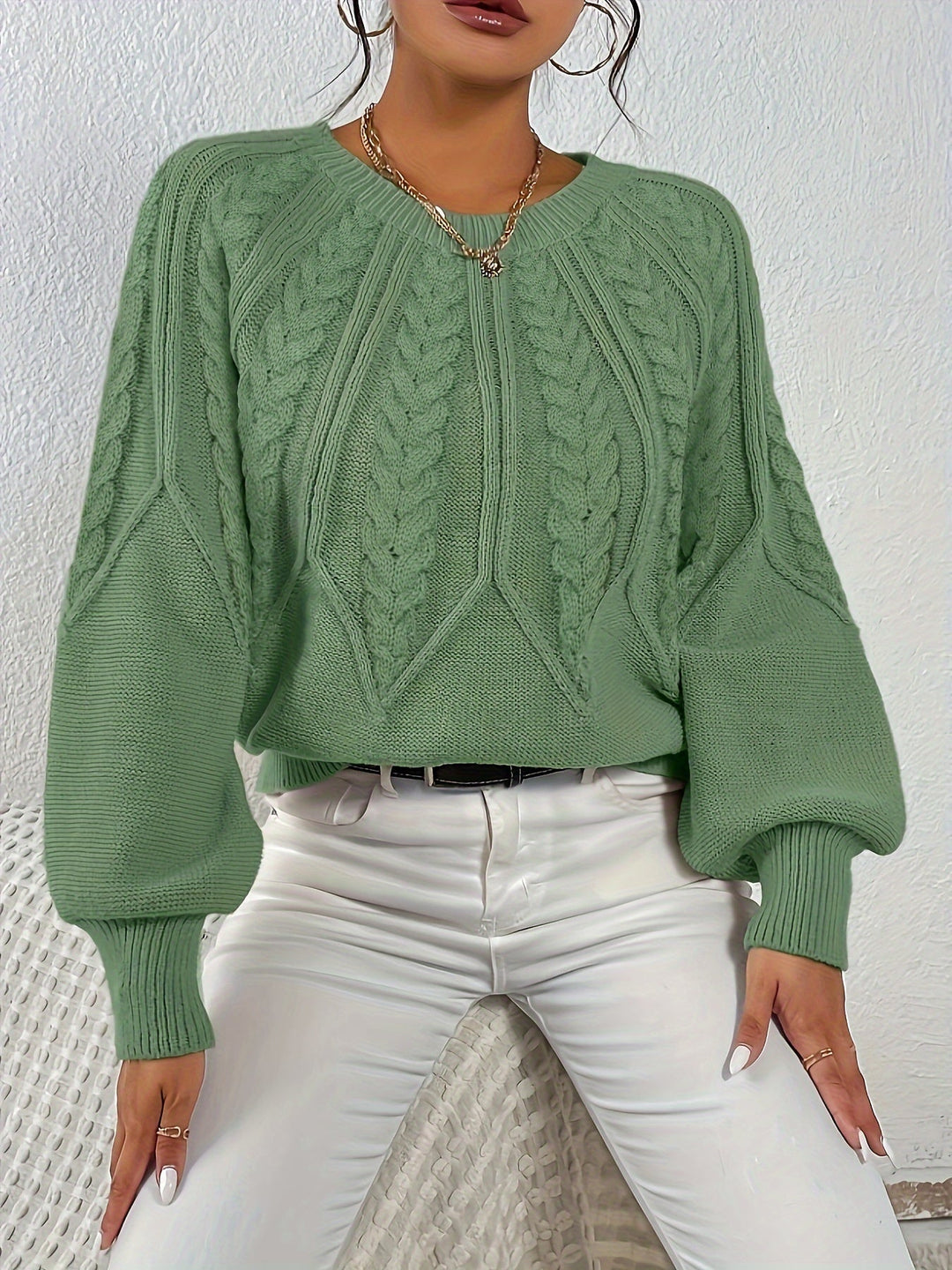 Stylish women's relaxed fit cable knit sweater with trendy lantern sleeves for winter.