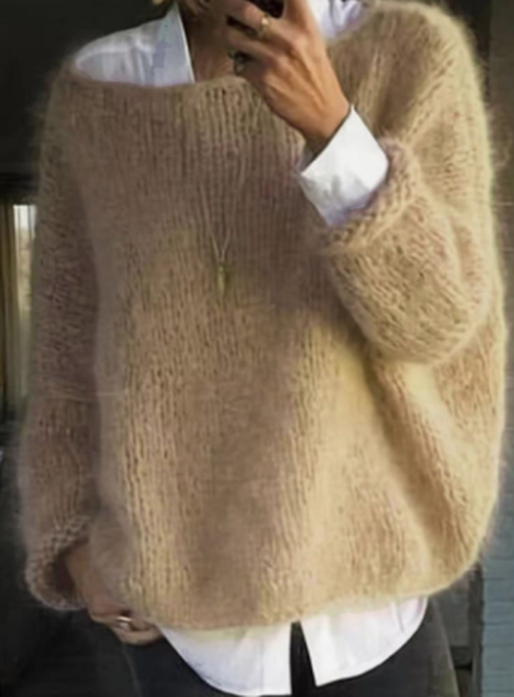 Stylish women's warm knit long sleeve sweater draped over a chair, ready for cool weather.