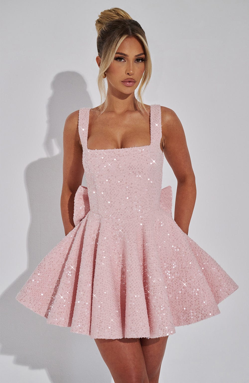Women's dazzling pink sequin backless bow mini dress for glamorous parties & special occasions.