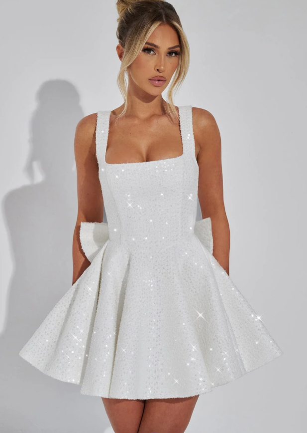 Detail of the elegant bow on the back of a women's dazzling sequin mini party dress.