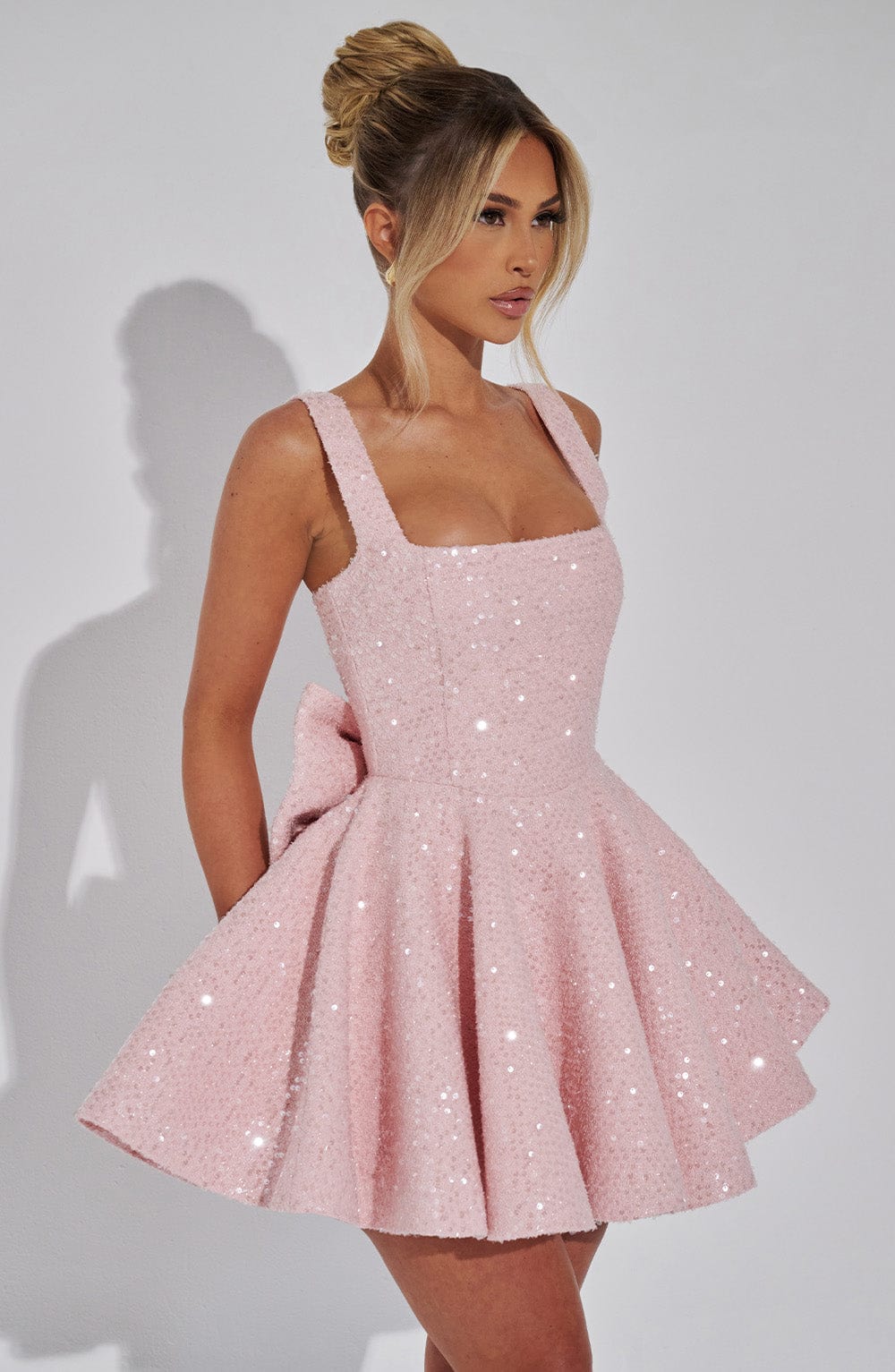 Elegant white sequin A-line mini dress for women, featuring a stunning backless design and chic bow.