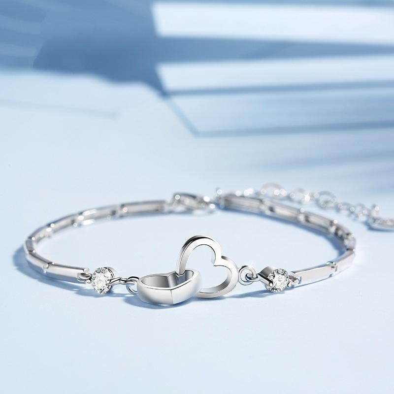 Romantic silver bracelet featuring two intertwined crystal hearts, a thoughtful gift for her.