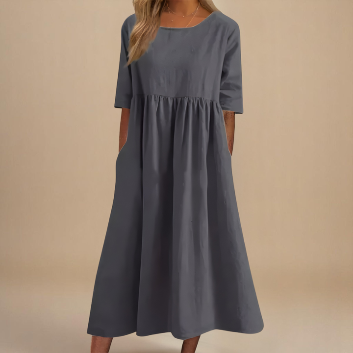 Stylish women's empire waist midi dress with practical pockets, half sleeves, and a flattering gathered waist.