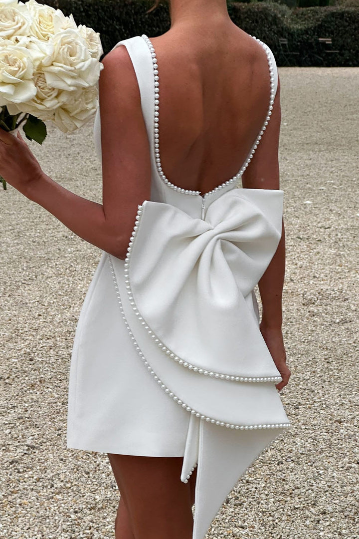 Chic sleeveless A-line mini dress for women, featuring a stunning statement bow & delicate pearl trim.
