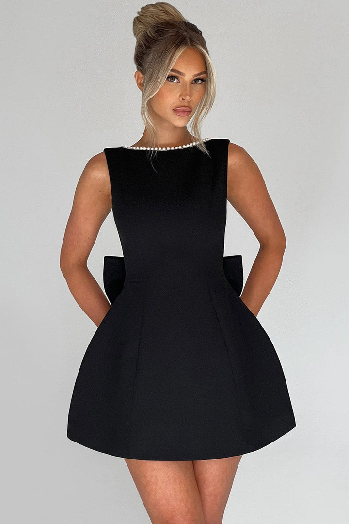 Beautiful party dress for women. A-line mini, adorned with pearl trim & a prominent back statement bow.