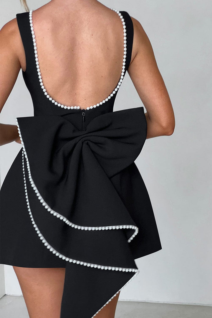 Modern elegant A-line mini dress for women, with exquisite pearl trim and a striking oversized bow detail.