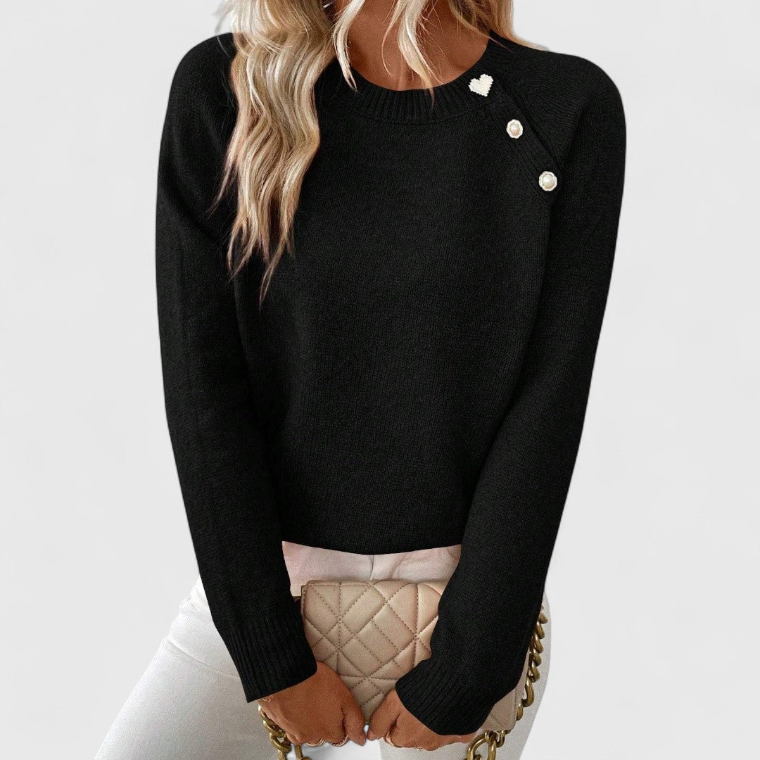 Women's elegant crew neck pullover sweater with sophisticated pearl button detail.
