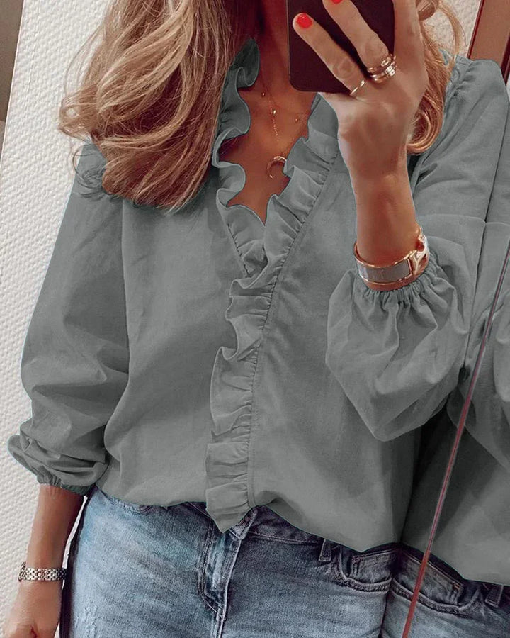 Chic women's long sleeve V-neck shirt with playful ruffle trim, a stylish and versatile fashion top.