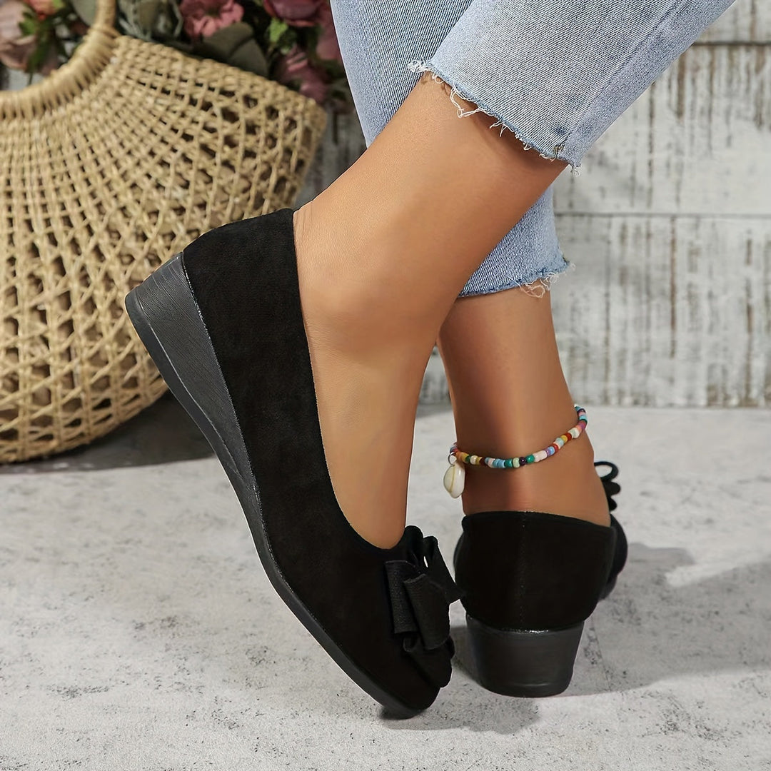 Elegant women's slip-on shoes featuring a sophisticated bow detail on comfortable wedge heels.