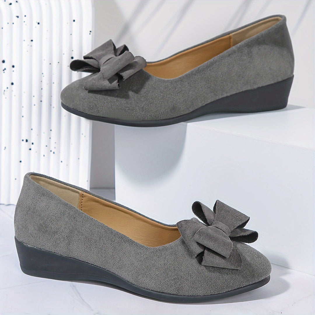 Elegant women's wedge heels with a charming bow, ideal for dress or casual wear. Slip-on design.
