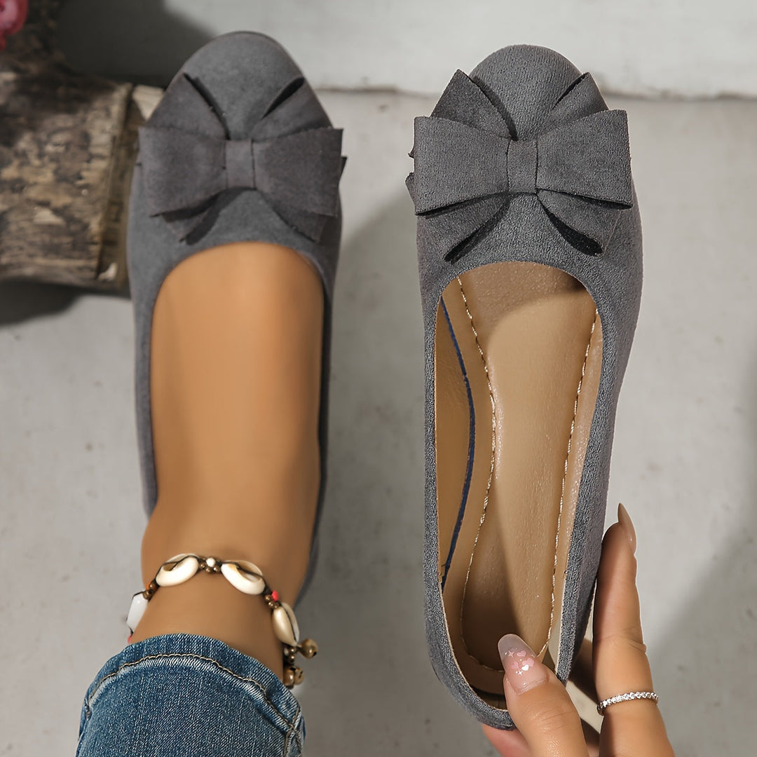 Modern ballet flat style women's slip-on wedge shoes with a decorative bow. Comfortable ladies footwear.