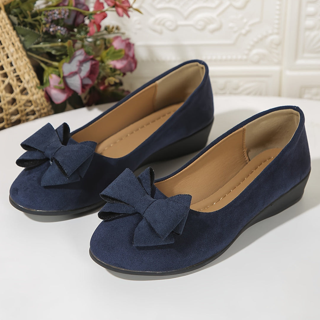 Easy-wear women's slip-on wedge shoes. Comfortable design with an elegant bow for stylish walking.