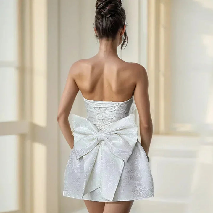 Elegant strapless mini dress for women with a beautiful bow back. Ideal short dress for parties & cocktails.