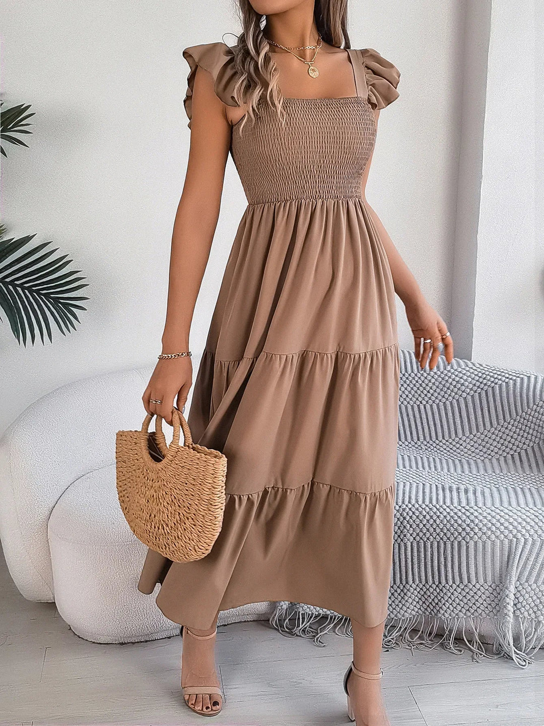 Chic women's smocked tiered midi dress with ruffle sleeves, offering a comfortable, flowy fit.