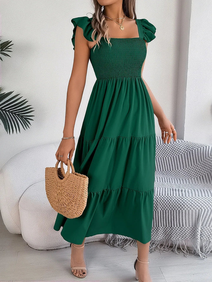 Flowy women's tiered midi dress, an elegant and chic smocked design with ruffle sleeves for summer.