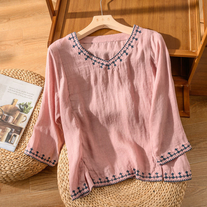 Flowing women's V-neck top featuring elegant embroidery & short sleeves. Versatile comfort for spring & summer fashion.