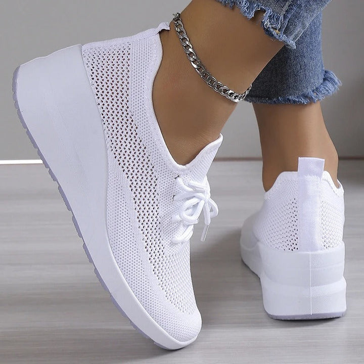 Side view of women's elevated platform wedge sneakers in a chic color, designed for comfort.