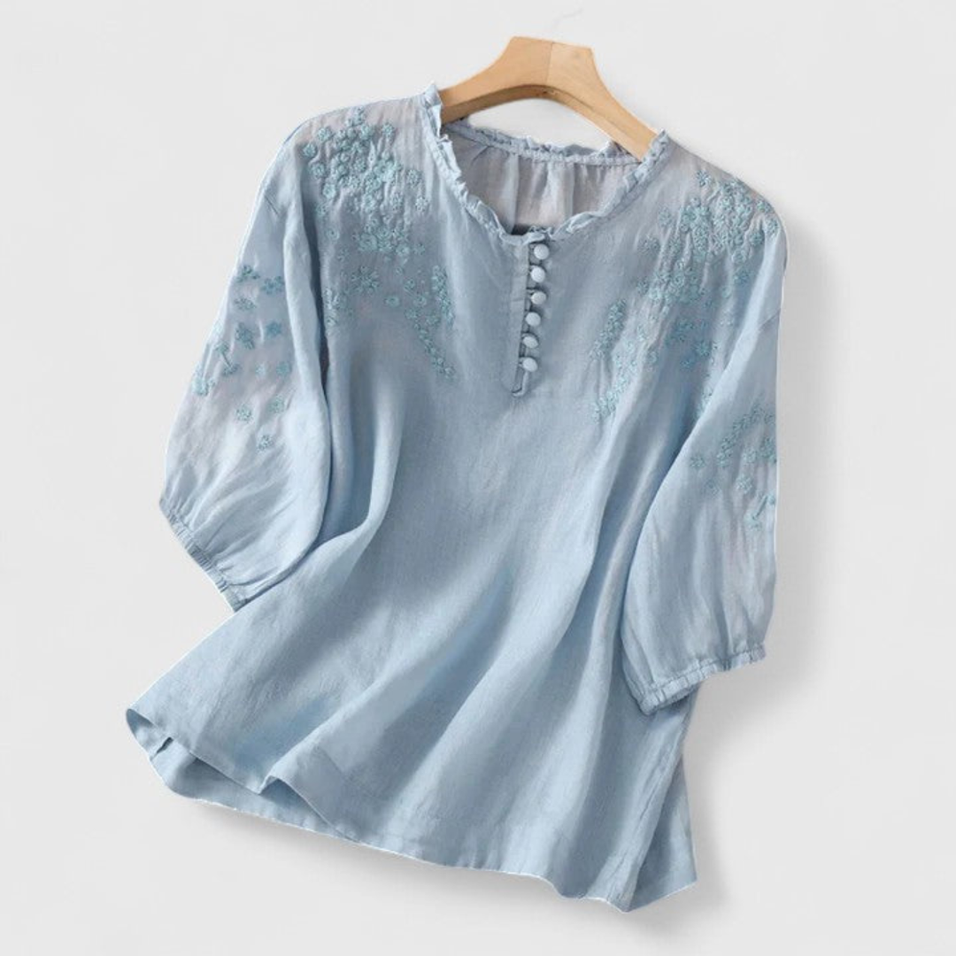 Boho chic women's blouse featuring delicate embroidery, three-quarter sleeves & a feminine ruffle collar for casual wear.