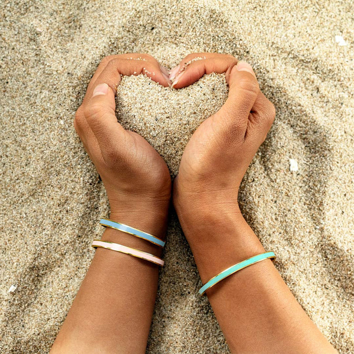 Stack of colorful stainless steel bangles for women, engraved with various positive messages