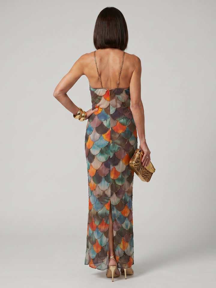 Close-up of a women's fitted halter maxi dress, showcasing its intricate geometric print and fluid fabric.