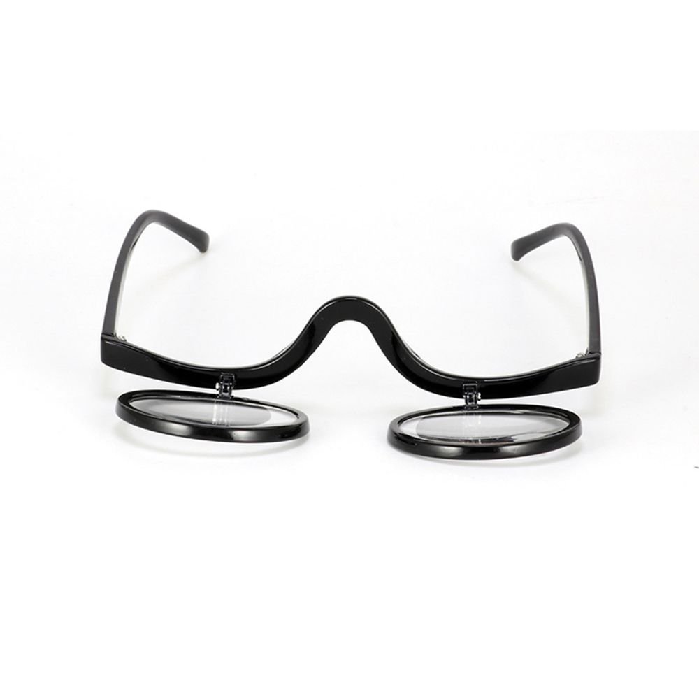 Beauty accessories: women's flip-down magnifying glasses next to makeup brushes, ready for use.