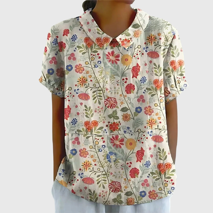 Close-up of the elegant neckline and sleeves of a feminine floral blouse for women.