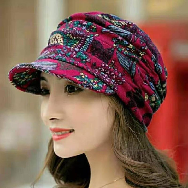 Women's floral pleated cap displayed on a mannequin head, highlighting its stylish short brim.