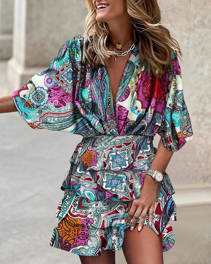 Woman modeling a vibrant floral print long sleeve wrap midi dress with a tiered ruffle skirt, ideal for autumn.