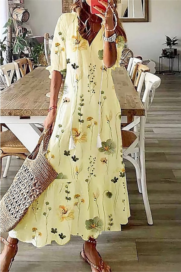 Elegant women's V-neck maxi dress with a delicate floral print, comfortable flowy fabric, and playful tassel detail.