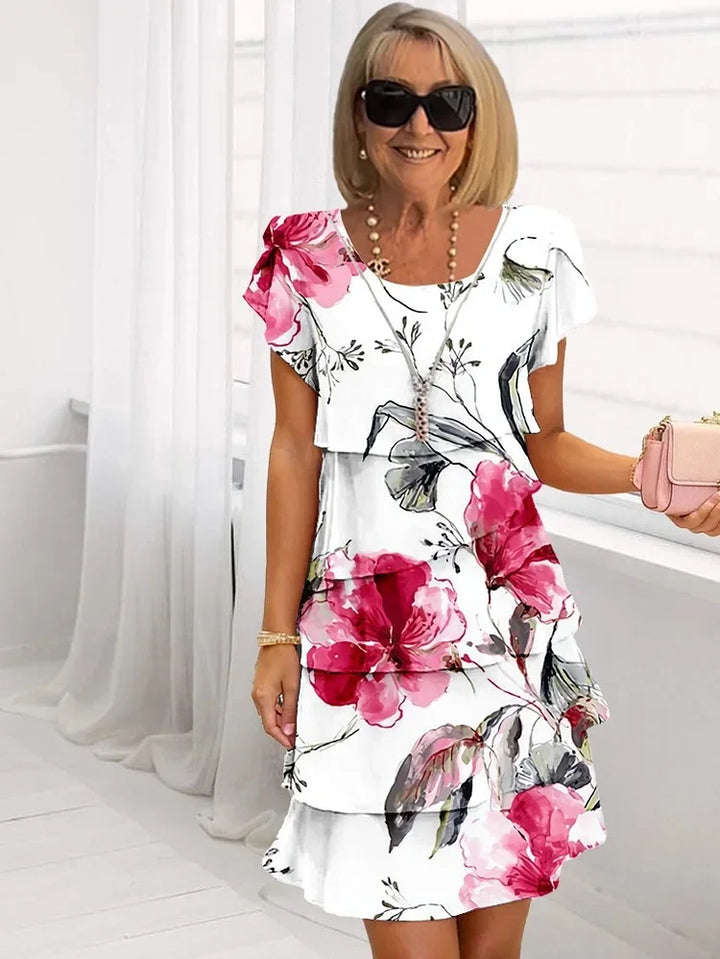 Women's floral tiered mini dress with short sleeves, perfect for casual spring/summer wear. Relaxed fit & vibrant print.