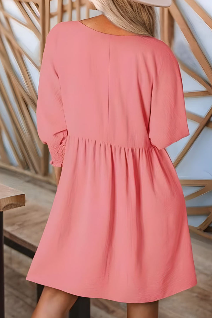 Women's elegant flowy babydoll mini dress with smocked cuffs. Ideal for warm weather, casual chic style.