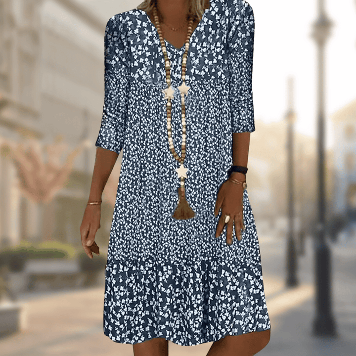 Women's flowy floral print tiered summer dress with V-neck & three-quarter sleeves, perfect for casual wear.