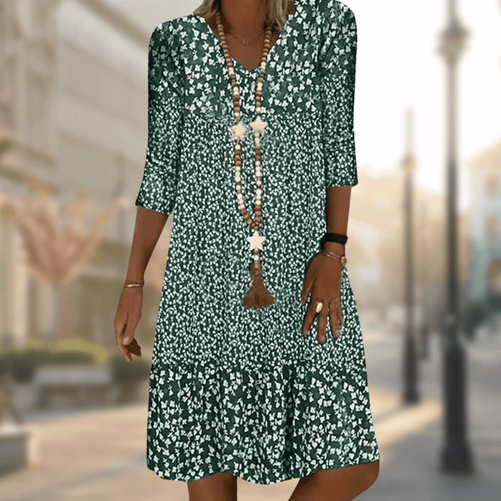Elegant women's flowy tiered summer dress featuring vibrant floral print, V-neck, and practical three-quarter sleeves.