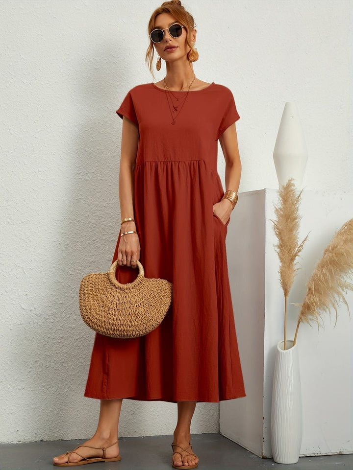 Woman enjoying summer in a casual chic flowy maxi dress with pockets, emphasizing comfort & everyday wear.