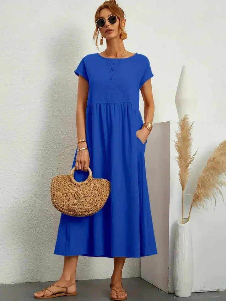 Stylish women's flowy maxi dress for versatile wear. Features a round neck, short sleeves, loose fit & pockets.